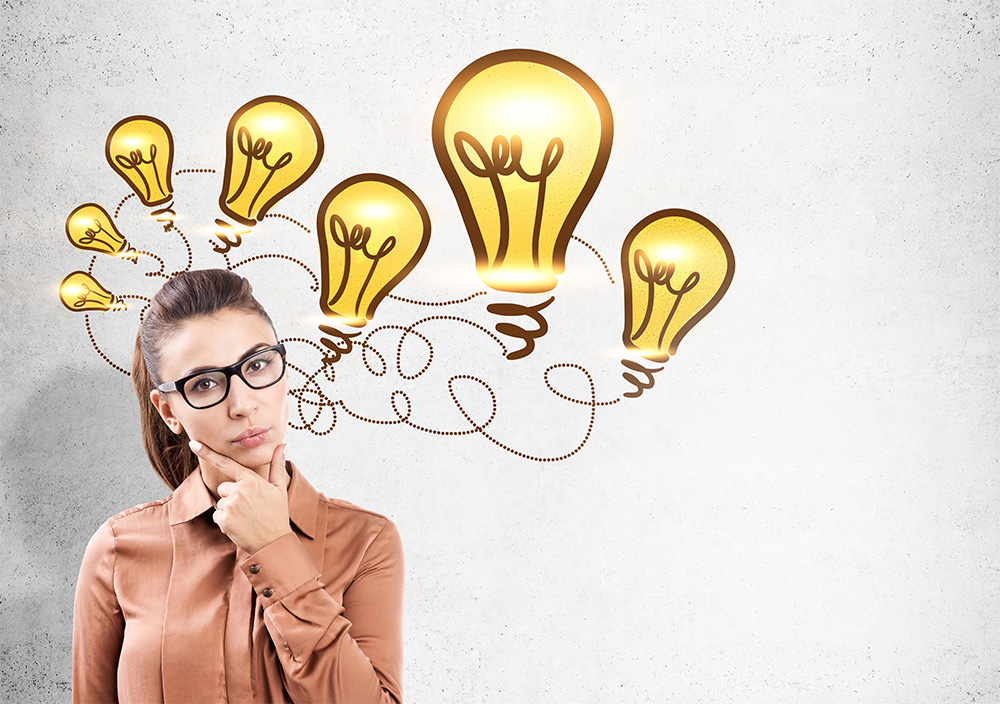 Photograph of a businesswoman with intersecting light bulbs above her head representing idea chains